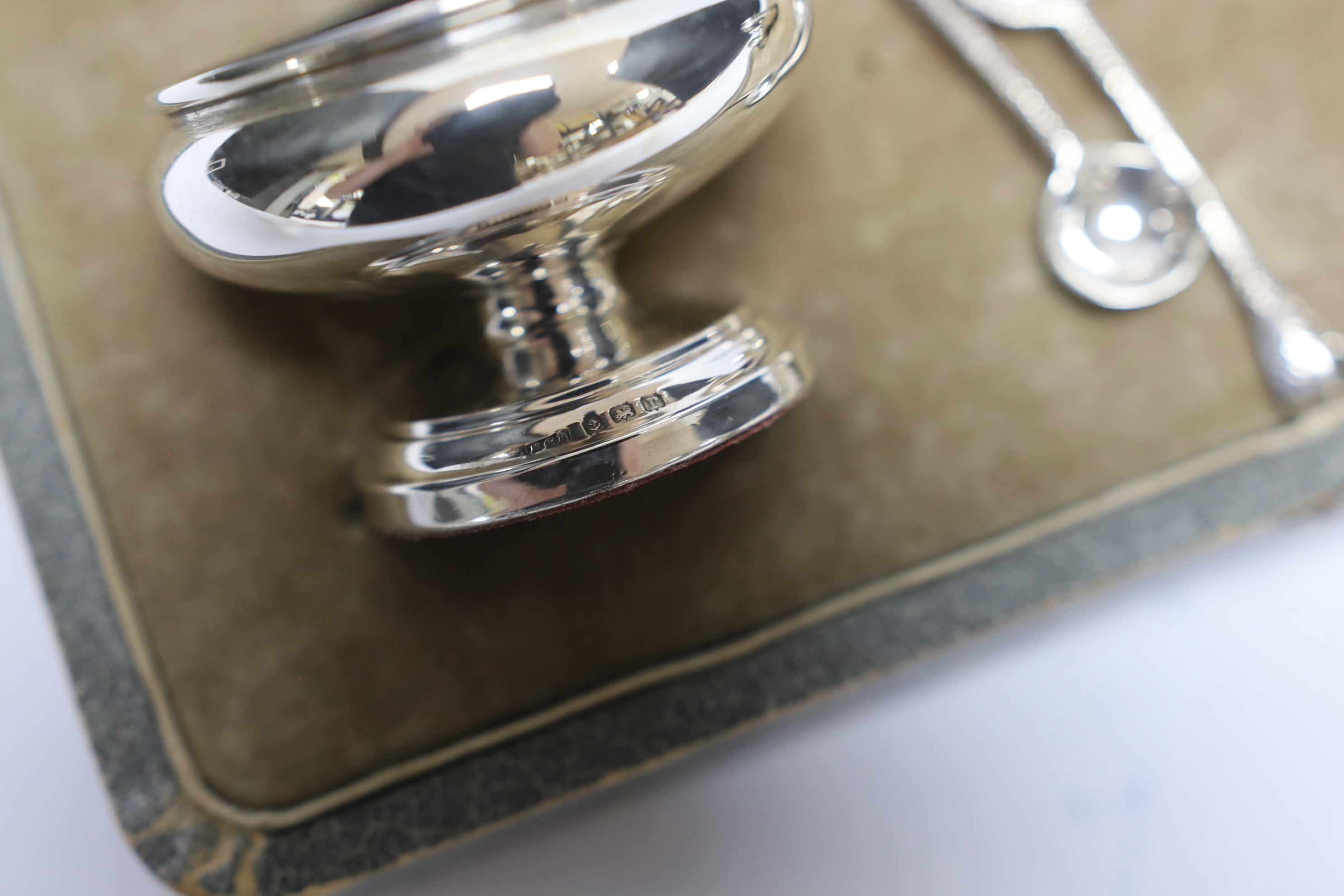 A cased George V silver five piece condiment set, Henry Clifford Davies, Birmingham, 1913 & 1917, with two associated plated spoons.